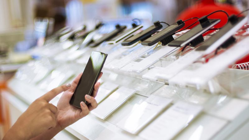 consumidor numa loja a ver telemóveis